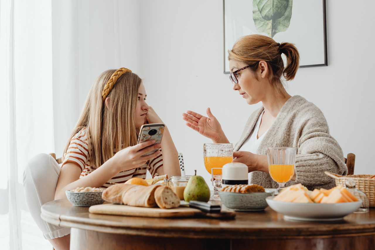 食卓で娘と向き合って話す母親／思春期の子との会話のイメージ