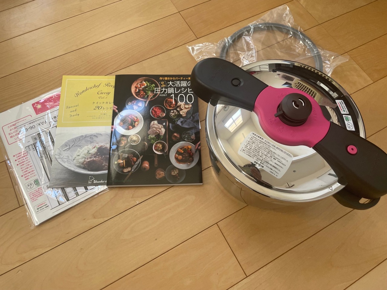 圧力鍋本体と付属のレシピ本・取扱説明書