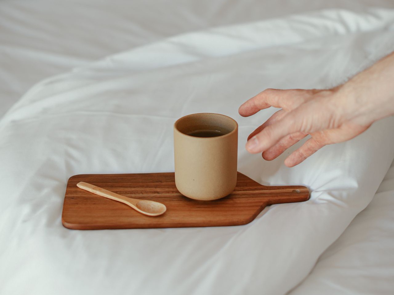 ベッドのトレーに置かれたあたたかい飲み物のイメージ